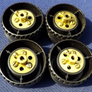 Four Meccano plastic road wheels, part 187c, with brass bush wheels, ect.